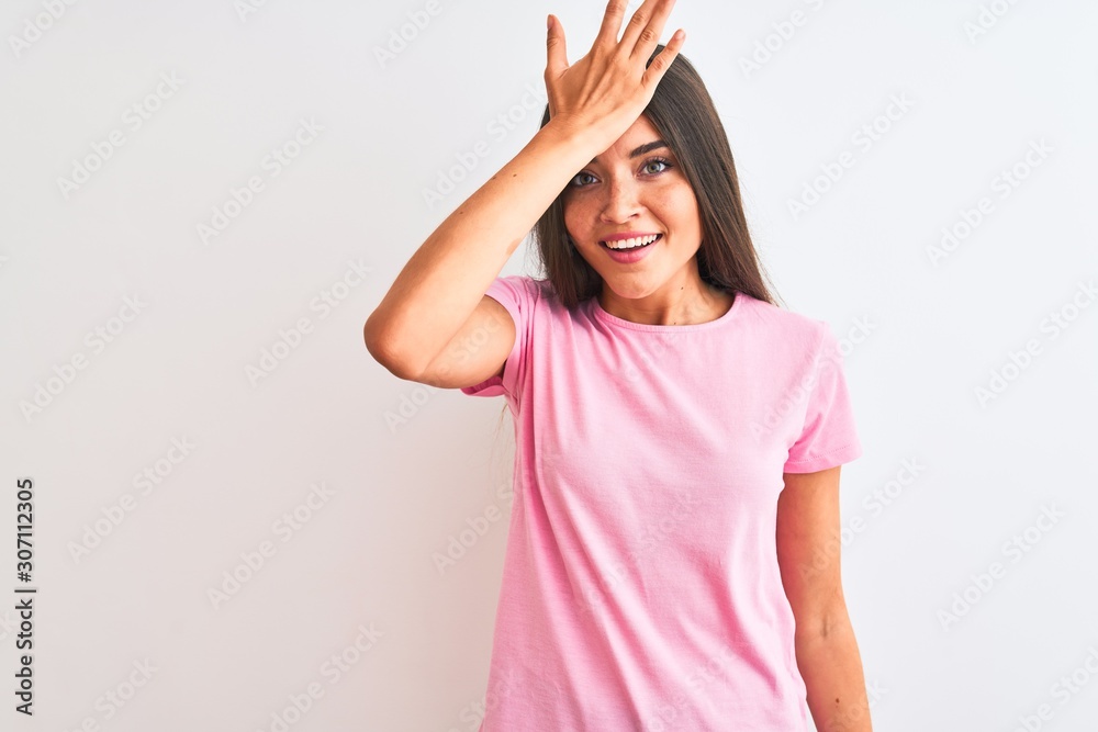 Young beautiful woman wearing pink casual t-shirt standing over isolated white background surprised with hand on head for mistake, remember error. Forgot, bad memory concept. Young beautiful woman wearing pink casual t-shirt standing over isolated white background surprised with hand on head for mistake, remember error. Forgot, bad memory concept.