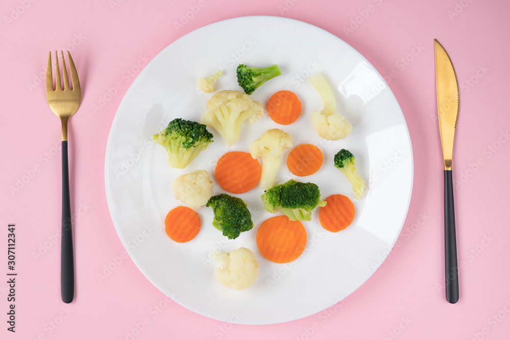 Plate of vegetables on pink background Plate of vegetables on pink background