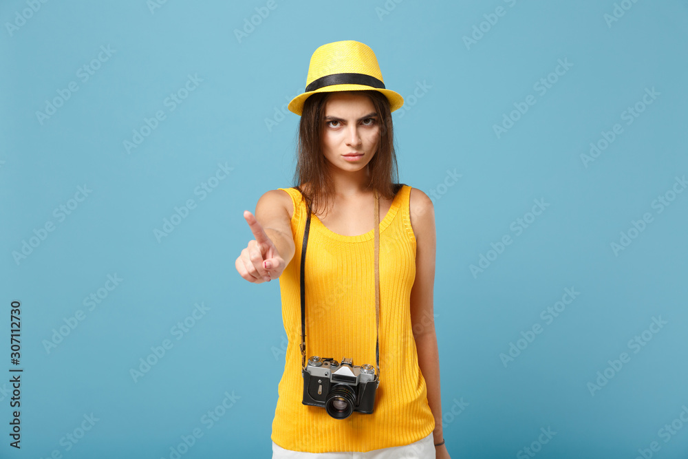 Traveler tourist woman in yellow summer casual clothes hat with photo camera isolated on blue background. Female sad passenger traveling abroad to travel on weekends getaway Air flight journey concept