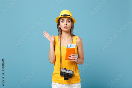 Traveler tourist woman in yellow summer casual clothes hat hold tickets camera isolated on blue background. Female passenger traveling abroad to travel on weekends getaway. Air flight journey concept. © ViDi Studio