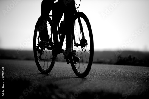 Fototapeta Naklejka Na Ścianę i Meble -  Black and white photo of the road bike and legs of a man.