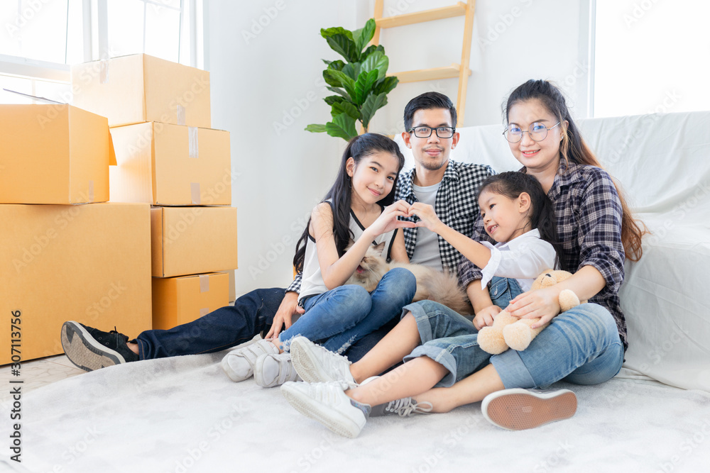 asian family relax and sitting on floor near sofa, they moving to new resident, they feeling happy and smile in family time, asian girl show heart sign with hand asian family relax and sitting on floor near sofa, they moving to new resident, they feeling happy and smile in family time, asian girl show heart sign with hand