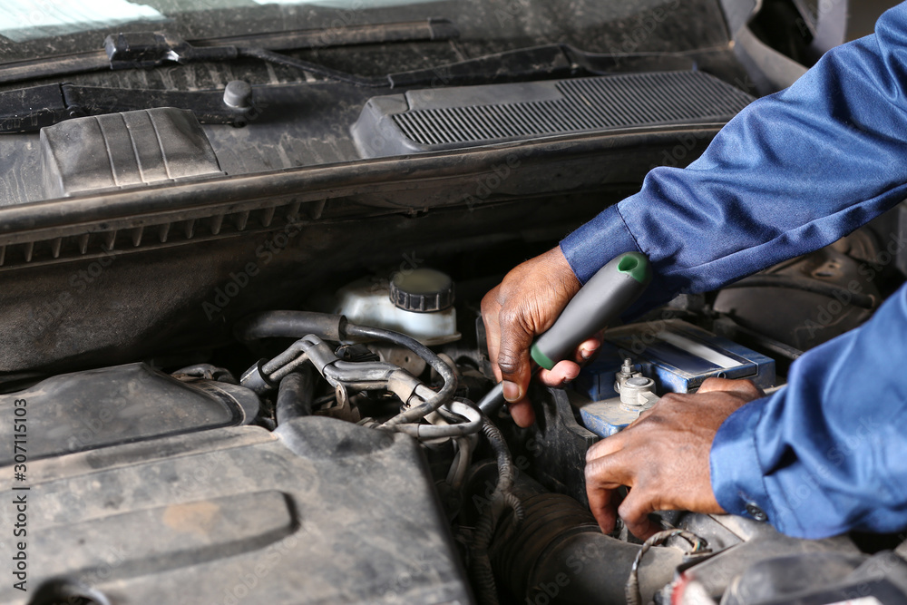 African-American mechanic working in car service center, closeup African-American mechanic working in car service center, closeup
