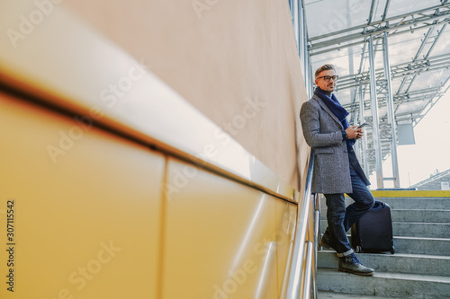 Wallpaper Mural Handsome stylish man with cellphone standing on steps Torontodigital.ca