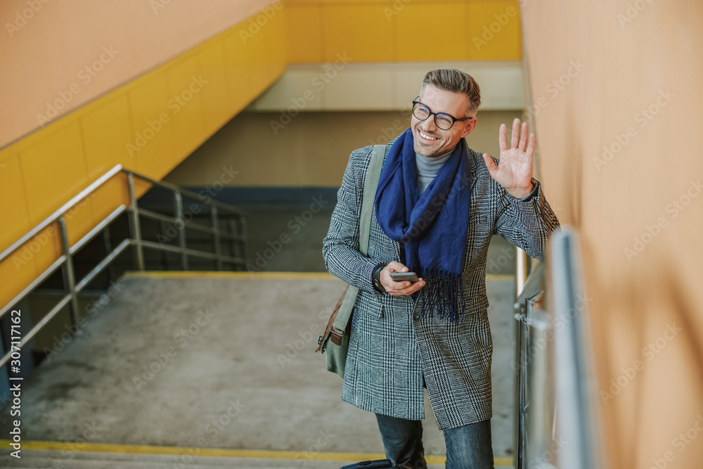 Cheerful handsome man saying hello to friend Cheerful handsome man saying hello to friend