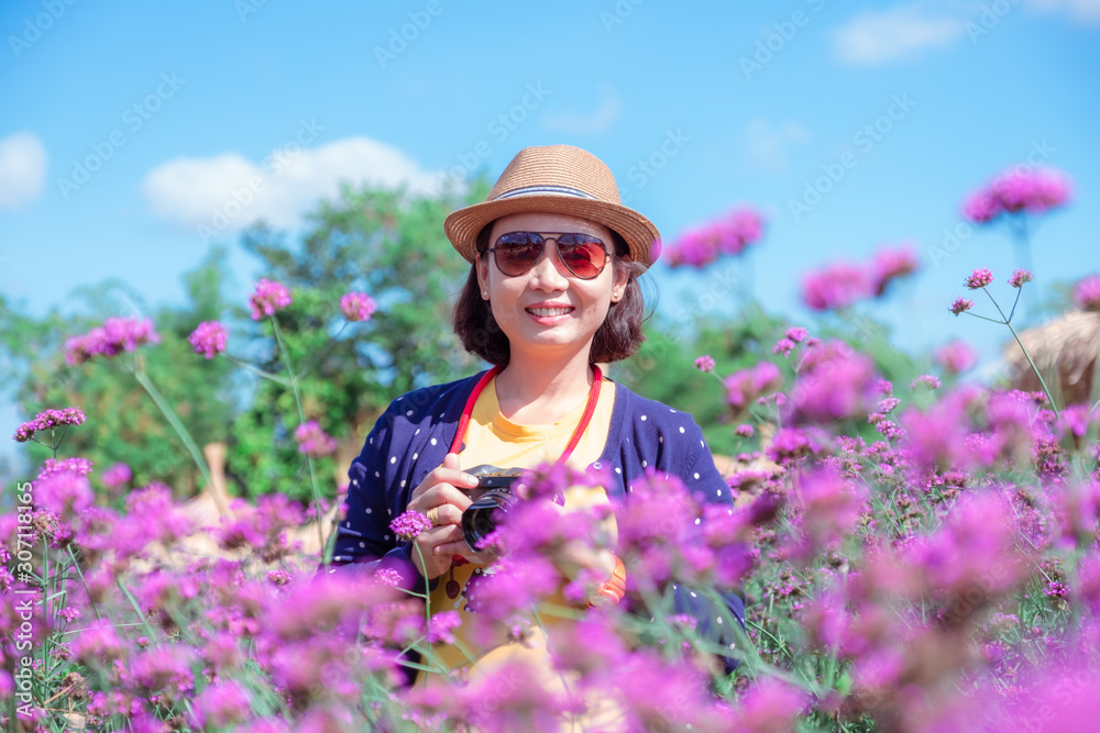 Asian women in Verbena bonariensis flower field with blue sky backgroud. Purple flower vintage, blurred and soft background. Asian women in Verbena bonariensis flower field with blue sky backgroud. Purple flower vintage, blurred and soft background.