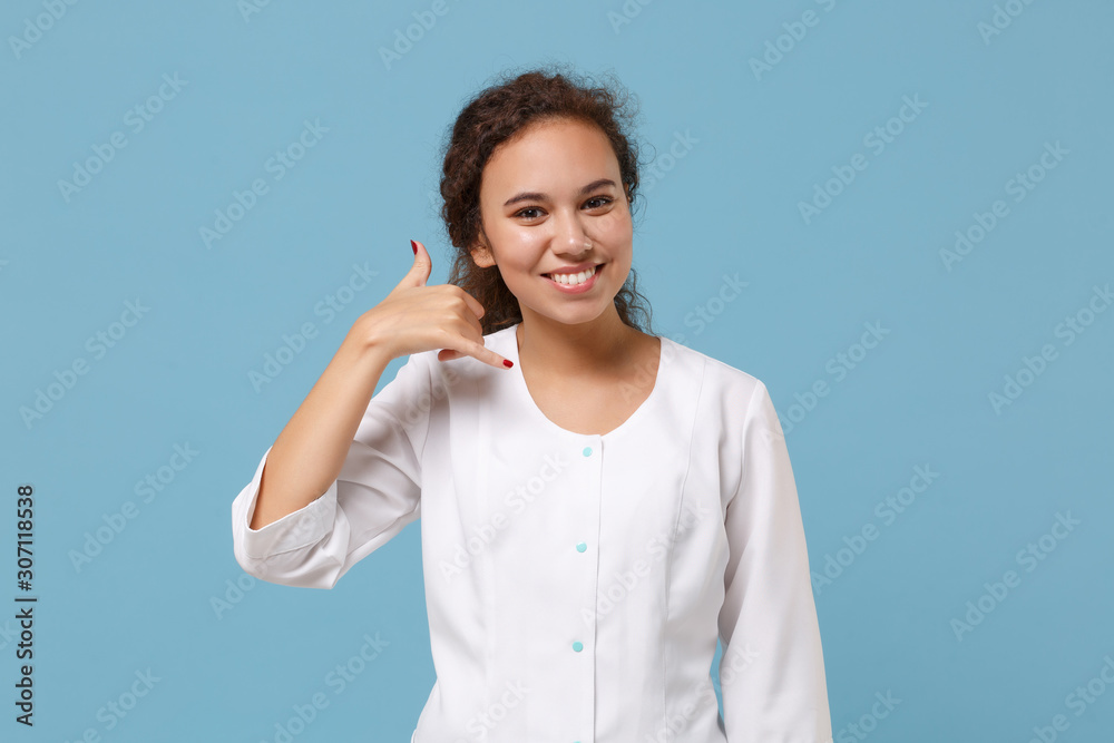 African american doctor woman isolated on blue background. Female doctor in medical gown doing phone gesture like says call me back. Healthcare personnel health medicine concept. Mock up copy space. African american doctor woman isolated on blue background. Female doctor in medical gown doing phone gesture like says call me back. Healthcare personnel health medicine concept. Mock up copy space.