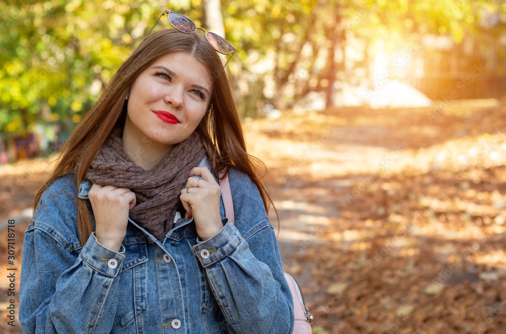 A young woman walks in the park. Autumn weekend in the city. Travel to the nature.