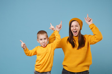 Woman in yellow clothes have fun posing with cute child baby boy 4-5 years old. Mommy little kid son isolated on blue background studio portrait. Mother's Day love family parenthood childhood concept.