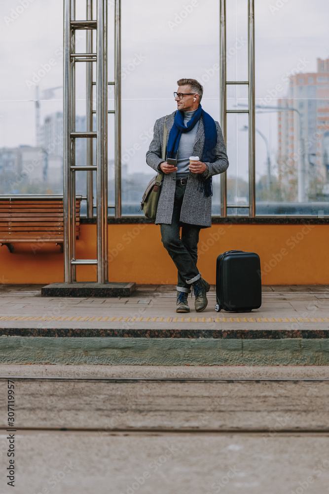 Handsome stylish holding smartphone and coffee cup Handsome stylish holding smartphone and coffee cup