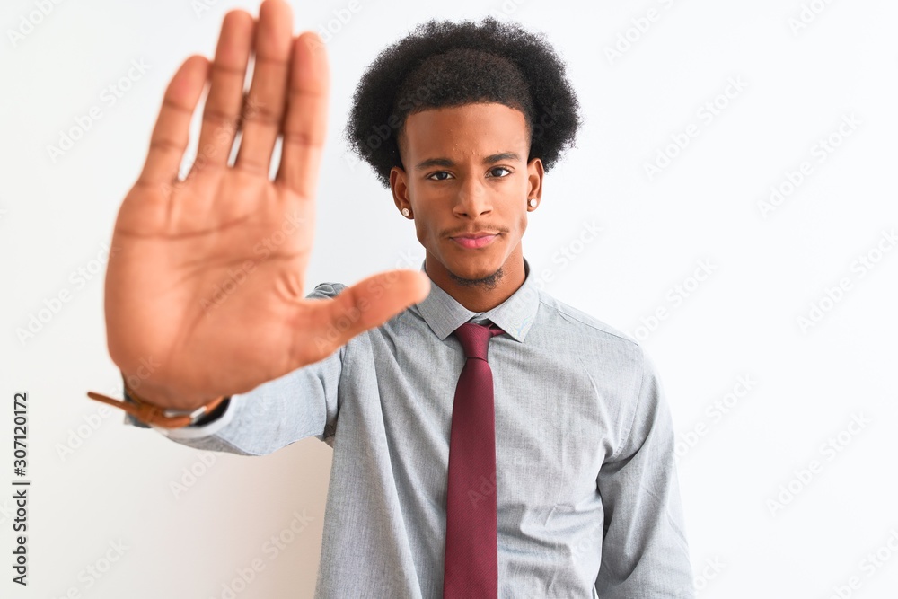 Young african american businessman wearing tie standing over isolated white background doing stop sing with palm of the hand. Warning expression with negative and serious gesture on the face. Young african american businessman wearing tie standing over isolated white background doing stop sing with palm of the hand. Warning expression with negative and serious gesture on the face.