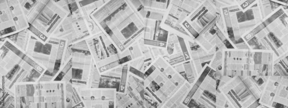 Long horizontal banner with lots of old newspapers on horizontal surface. Background texture, top view, blurred. Concept for news and information - could be used for web design or advertisement