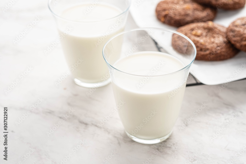 Chocolate cookies on a wire rack with milk on a white background. Chocolate cookies on a wire rack with milk on a white background.