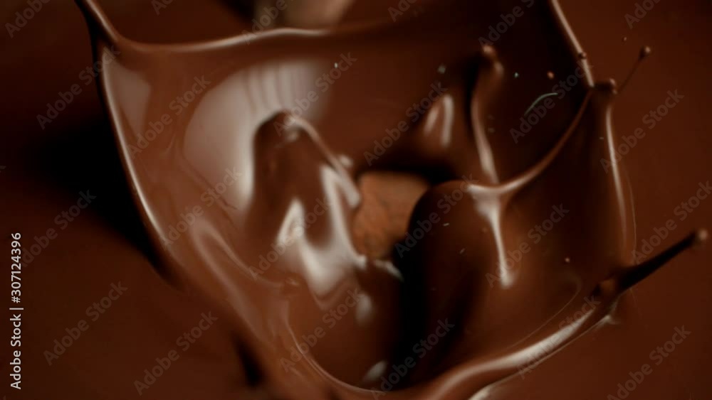 Super slow motion of flying raw chocolate pieces splashing into molten chocolate. Filmed on high speed cinema camera, 1000fps.