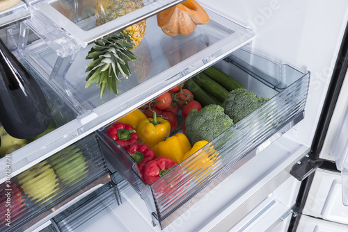 Open fridge full of fresh fruits and vegetables photo