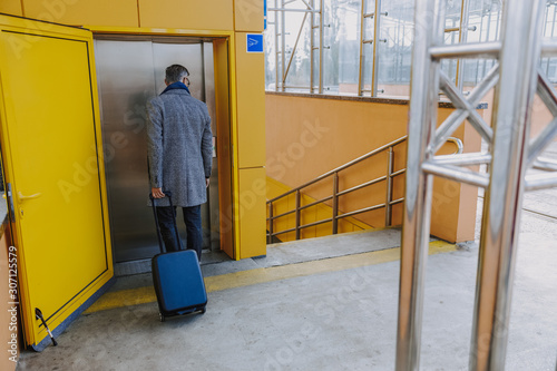 Stylish man with travel suitcase waiting for lift © Yakobchuk Olena