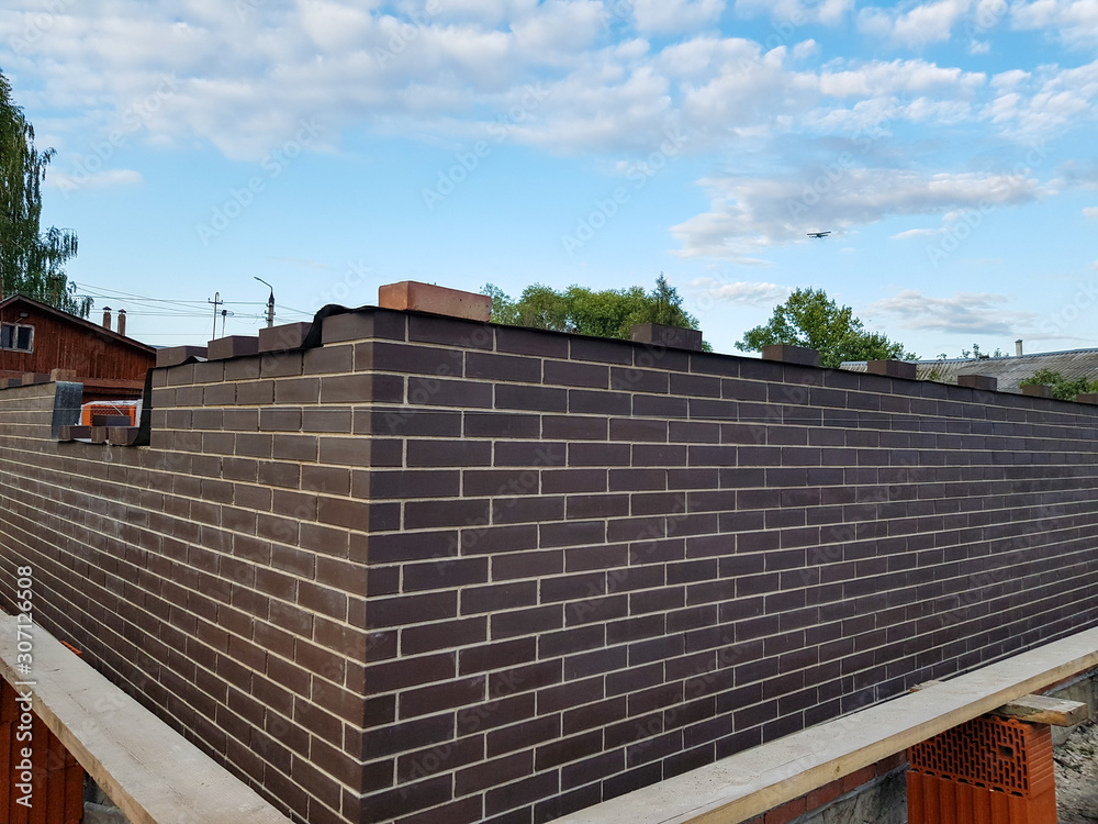 construction of a brown brick brick house with a white seam construction of a brown brick brick house with a white seam