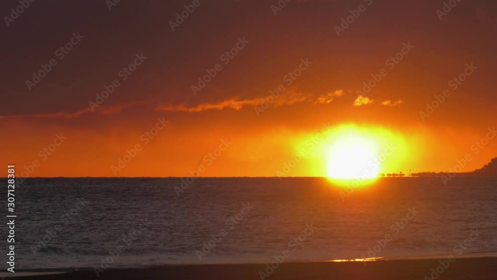 Dramatic hazy sunrise over dark ocean waves with orange dawn sky, coastal seascape Dramatic hazy sunrise over dark ocean waves with orange dawn sky, coastal seascape