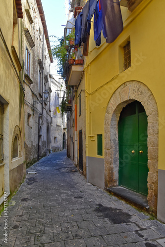 Fototapeta Naklejka Na Ścianę i Meble -  Sessa Aurunca, Italy, 11/30/2019. A small street among the old houses of a medieval village in the province of Caserta