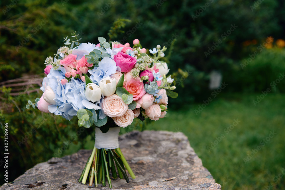 Close up of bridal bouquet of pink roses and blue hydrangea flowers on  stone background outdoors, copy space. Wedding concept Stock Photo | Adobe  Stock