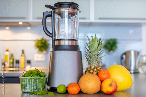 Different tropical fruits and smoothie on home kitchen background, healthy eating lifestyle concept