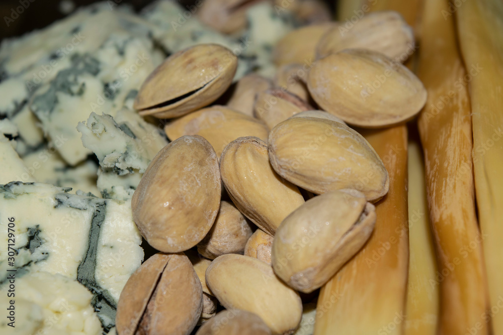 Obraz premium Salt-fried pistachios, Gorgonzola and smoked cheese. Close up