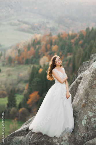 Beauty woman, bride with perfect white dress background mountains © olegparylyak