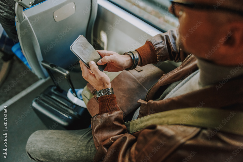 Gentleman using modern smartphone during bus ride