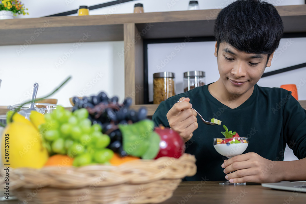 Handsome young men are happy to eat fruit yogurt. Handsome young men are happy to eat fruit yogurt.