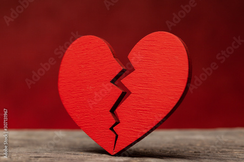 Broken heart. Crack in the red heart, Breaking the relationship. Red background.