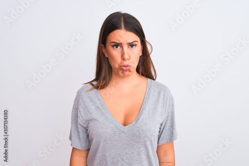 Portrait of beautiful young woman standing over isolated white background depressed and worry for distress, crying angry and afraid. Sad expression.