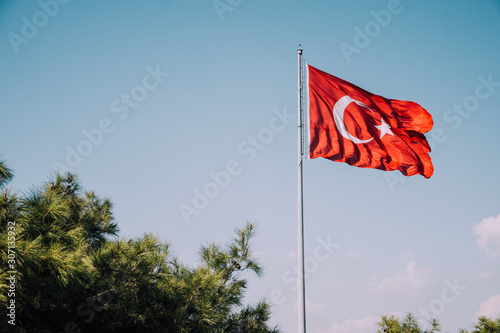 Turkish flag on sky background. Waving red flag. Turkish patriotism. Turkey Day. Cumhuriyet Bayramı. Izmir, Turkey. National Turkish flag.