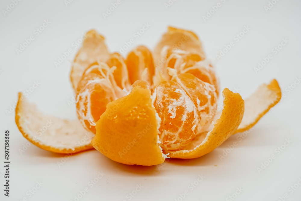 Slices of juicy tangerine disassembled into pieces close-up Slices of juicy tangerine disassembled into pieces close-up