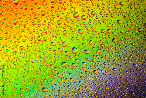 closeup of water droplets on a glass. Rainbow background  colorful abstract pattern.