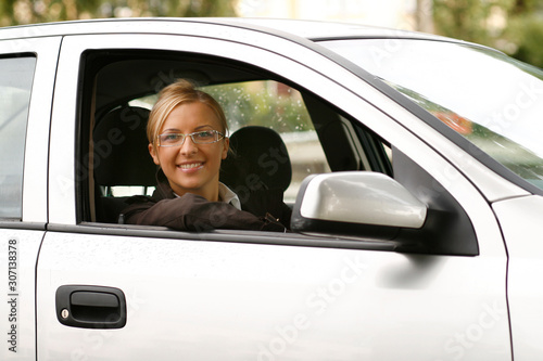 Young happy businesswoman driving a car
