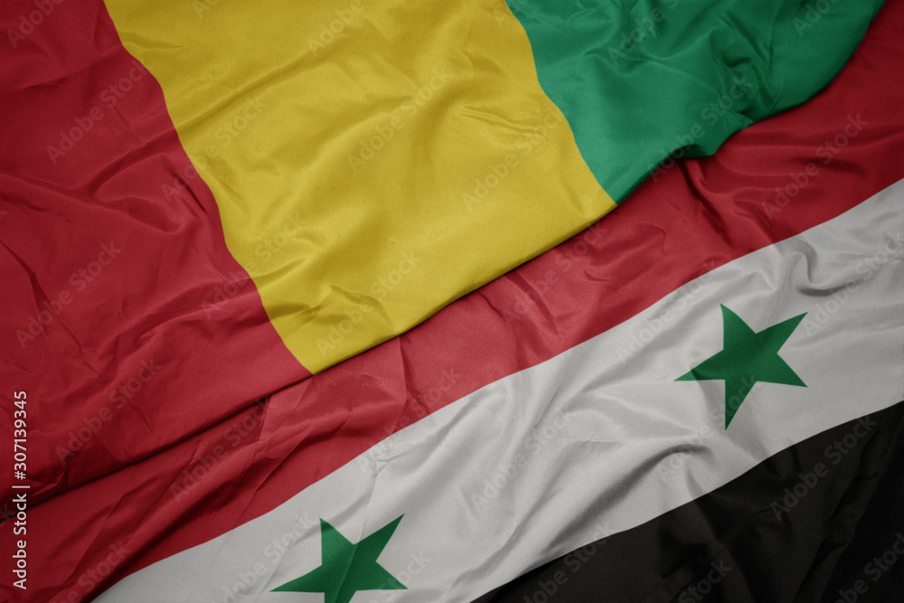 waving colorful flag of syria and national flag of guinea.