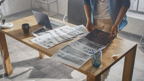 Foto Creative Designer Works on a Storyboard, Looks at His Sketches and Concepts, Choosing the Best Drawings for His Project