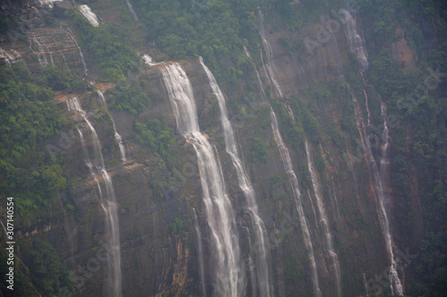 The seven sister falls cum Nohsngi Thiang Falls of Cherrapunjee  Shillong with lush green grasses  trees and mountains.