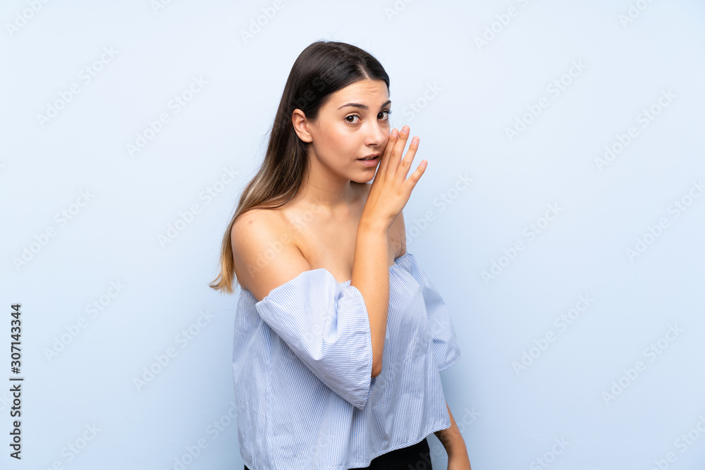 Young brunette woman over isolated blue background whispering something Young brunette woman over isolated blue background whispering something