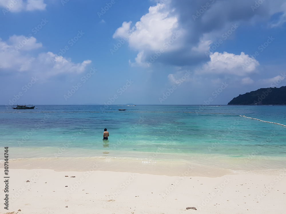 Man standing in water at Perhentian islands in Terengganu in Malaysia Man standing in water at Perhentian islands in Terengganu in Malaysia