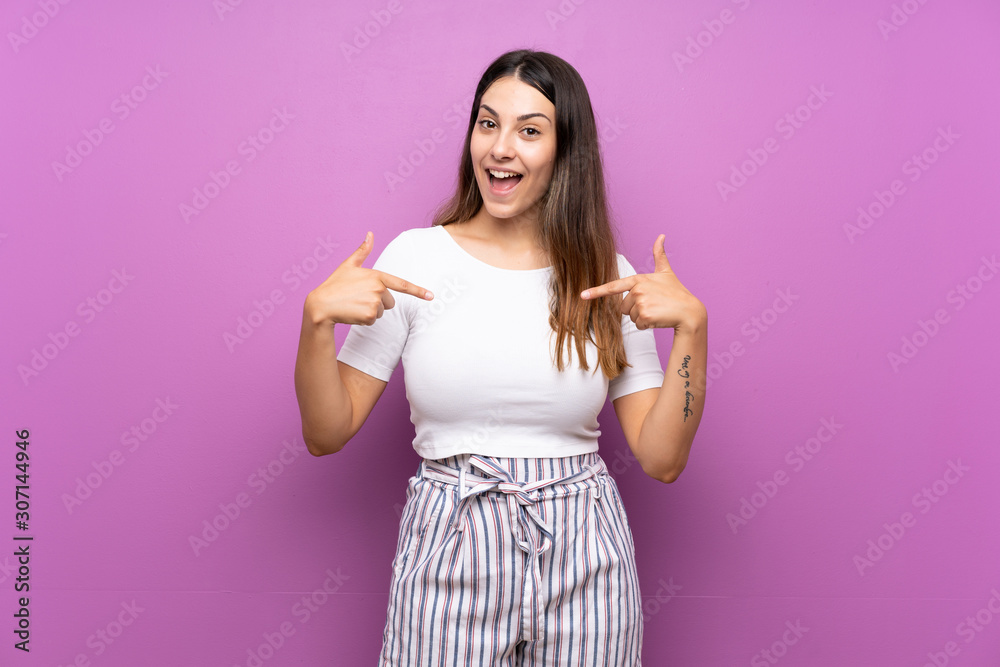 Young woman over isolated purple background proud and self-satisfied