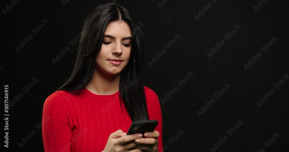 Girl writes lies to boyfriend in sms .Brunette woman using smartphone and typing isolated over black background. Girl write sms. Invent Girl writes lies to boyfriend in sms .Brunette woman using smartphone and typing isolated over black background. Girl write sms. Invent