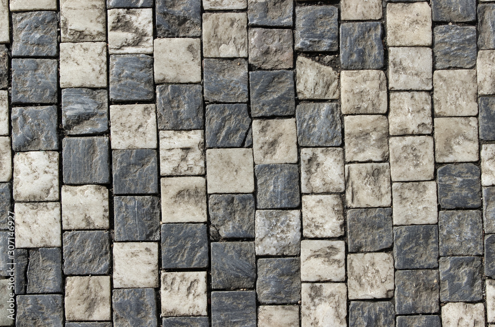 An old stoneblock pavement cobbled with square stone blocks