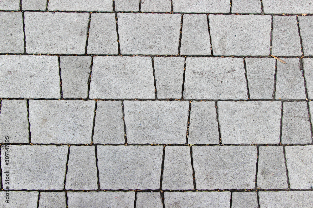 Sidewalk paved with two types of trapeziform gray tiles