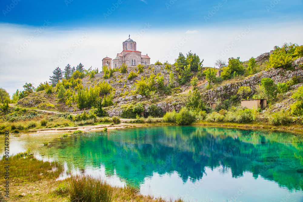 Croatia, Cetina river source water hole and small Orthodox church in Dalmatian Zagora karst landscape