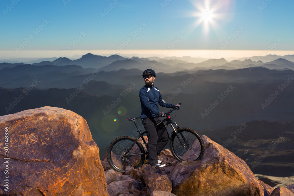 Cyclist in pants and fleece jacket on a modern carbon hardtail bike with an air suspension fork rides off-road.	