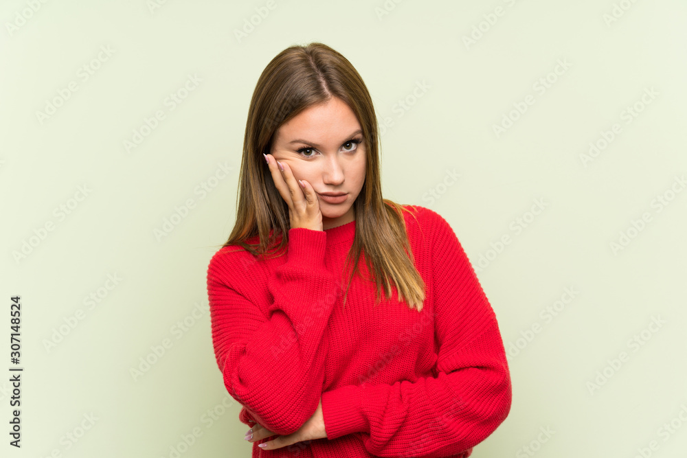Teenager girl over isolated green background unhappy and frustrated Teenager girl over isolated green background unhappy and frustrated