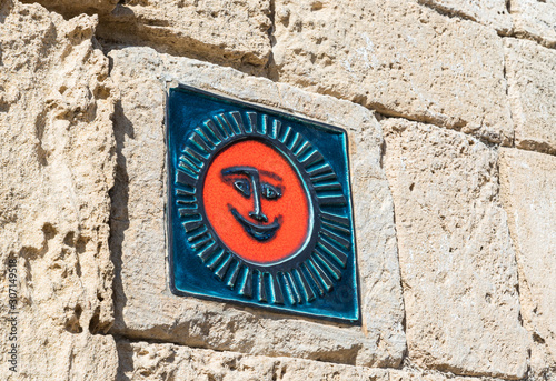 Stone tile with a smiling sun is on the wall in Caesarea city, on the shores of the Mediterranean Sea, in northern Israel