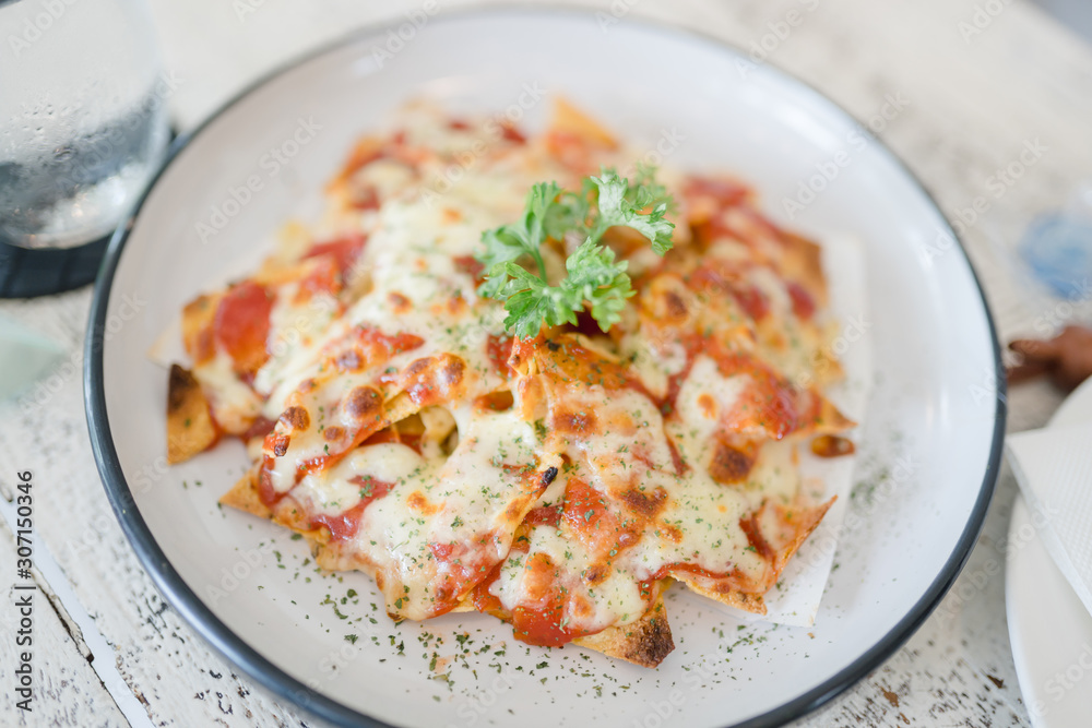 Top view of nachos and cheese.A plate of delicious plain nacho tortilla corn chips with cheese sauce.Mexican appetizer food. Top view of nachos and cheese.A plate of delicious plain nacho tortilla corn chips with cheese sauce.Mexican appetizer food.