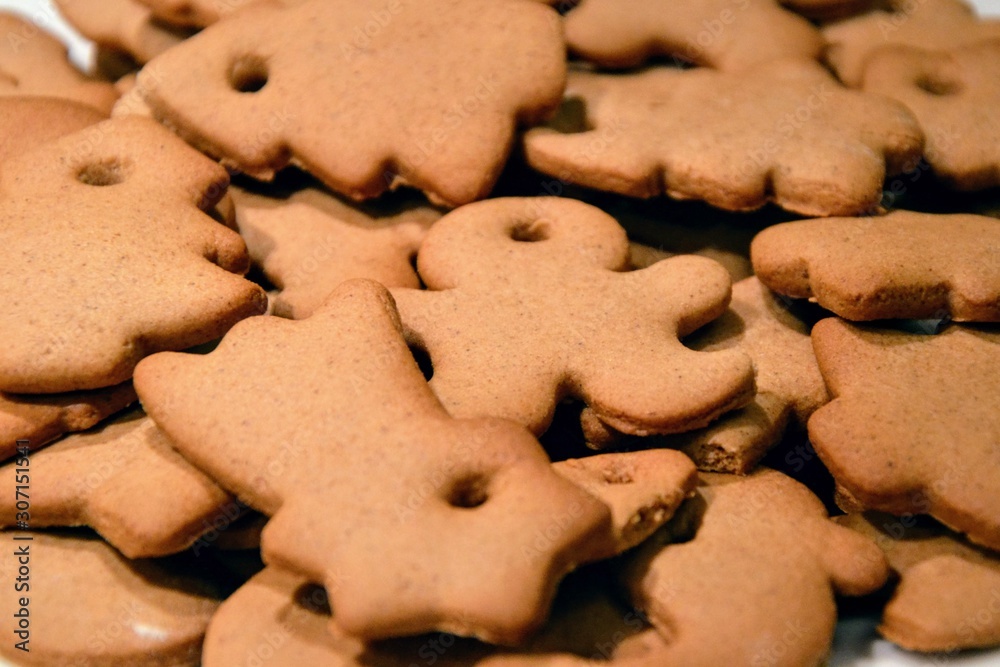 Christmas cookies background. Homemade gingerbread cookies in various shapes freshly made at home, golden browned colored cookies before decorating them with icing. Christmas cookies background. Homemade gingerbread cookies in various shapes freshly made at home, golden browned colored cookies before decorating them with icing.